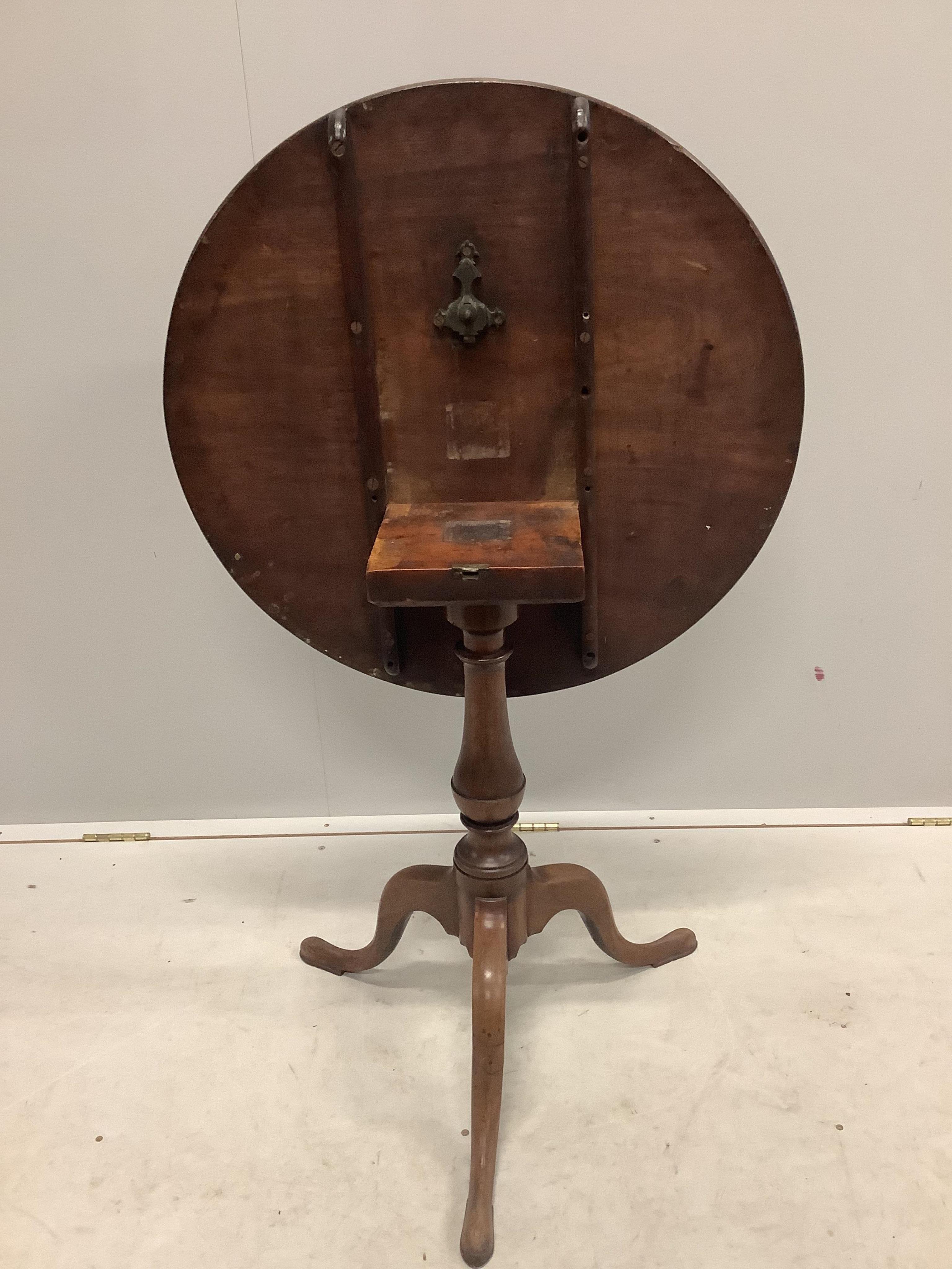 A George III circular mahogany tilt top tripod tea table, diameter 69cm, height 72cm. Condition - fair